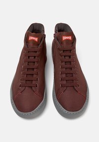 Baskets montantes bordeaux avec lacets et semelle grise, présentant un logo rouge "Camper" sur la languette, vues d'en haut.