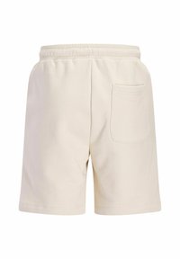 Short beige à taille élastique avec une seule poche plaquée au dos côté droit, fabriqué dans un tissu doux.