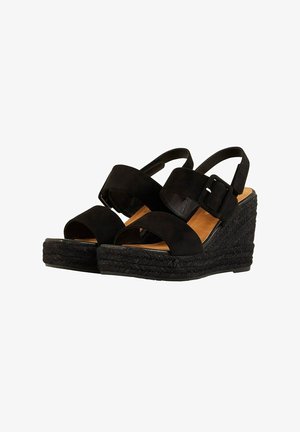 Sandalias de cuña negras con base de esparto, que presentan dos tiras anchas y un detalle de hebilla. Material superior liso con una suela texturizada.