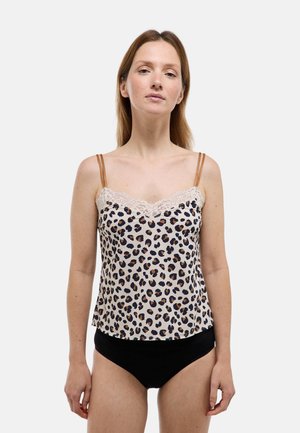 Femme portant une camisole à imprimé léopard avec bordure en dentelle et fines bretelles marron, associée à un sous-vêtement noir, debout devant un fond uni.