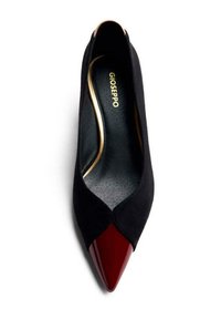 Zapato de tacón alto de ante negro con punta de charol rojo en forma puntiaguda. Presenta un diseño con cortes en curva y un logo dorado en la suela interna.