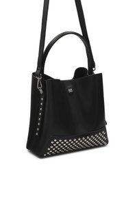 Sac à main en cuir noir avec des clous argentés sur le bas devant, deux poignées et une bandoulière plus longue sur fond blanc.