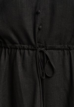 Mustad linasseel, millel on volditud vöökoht, paelaga, nööpidega ees ja tekstureeritud kangas. Sile ja kerge välimus.