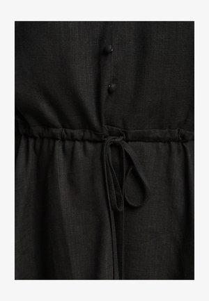 Mustad linasseel, millel on volditud vöökoht, paelaga, nööpidega ees ja tekstureeritud kangas. Sile ja kerge välimus.