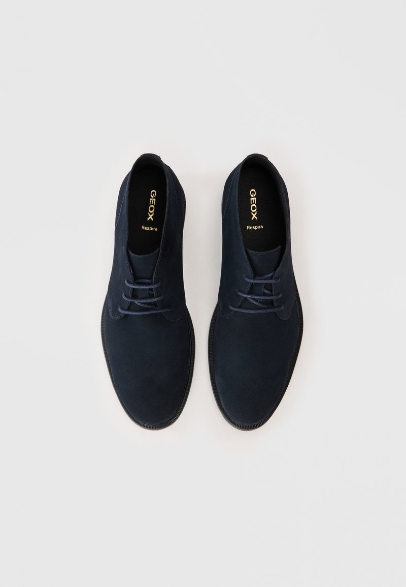 Navyblaue Wildleder-Dressschuhe mit glatter Textur, runder Spitze und farblich abgestimmten Schnürsenkeln. Mit Gummisohle und geprägtem "GEOX Respira"-Logo.