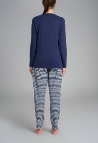 Maglietta a maniche lunghe blu abbinata a pantaloni del pigiama con motivo geometrico in blu e bianco. Tessuto morbido con una vestibilità comoda.