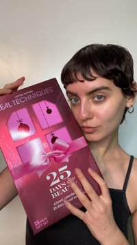 Limited Edition Real Techniques adventskalendercadeauset, met een glanzende kastanjebruine doos met roze accenten, strikken en 25 dagen aan beautyproducten.