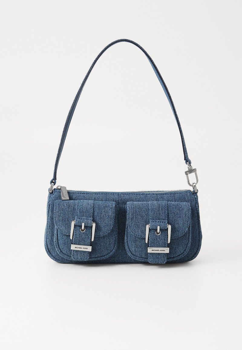 Sac en denim bleu foncé avec des accessoires en métal argenté. Il dispose de deux poches avant avec des fermetures à rabat et d'une seule bandoulière. Fermeture zippée sur le dessus.