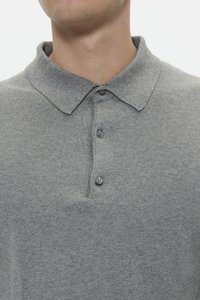 Polo grigio con colletto, dotato di tre bottoni e un tessuto testurizzato. Design semplice senza motivi o accenti.
