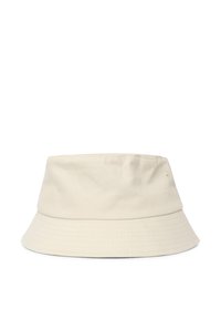 Cappello a secchiello in cotone beige con una larga visiera inclinata verso il basso, texture sottile e fori di ventilazione ad occhio sui lati.