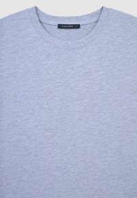 T-shirt in cotone grigio con collo rotondo a costine e etichetta con la scritta "CALLIOPE". Tessuto liscio con un aspetto leggermente melangiato. Etichetta della taglia visibile.