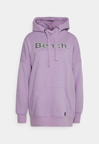 Lawendowa bluza z dużą kieszenią z przodu, sznurkami i logo "Bench." w grubych czarnych i białych literach na piersi.