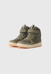 Olíva zöld, magas szárú sneakers bézs talppal, hálós panelekkel, fűzőkkel és tépőzáras pántokkal, egymás mellé helyezve egy szürke háttéren.