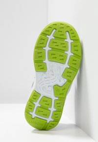 Suela de zapato con tracción verde, base blanca, patrón de lagarto en el centro, tamaño 25 y el nombre de la marca "LURCHI" en el talón.