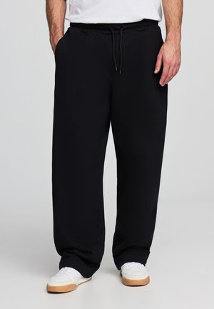 Pantaloni sportivi neri realizzati in morbido tessuto, con vita elastica e cordino, tasche laterali e vestibilità rilassata.