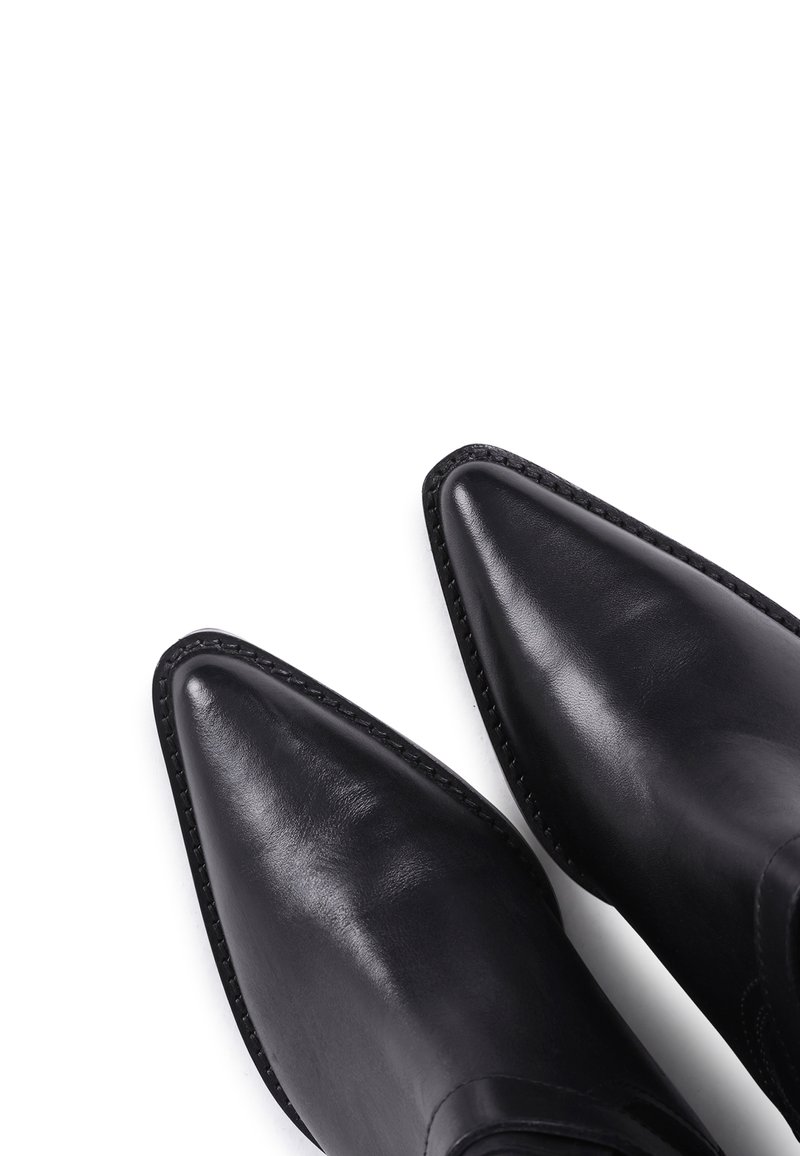 Czarne skórzane botki za kostkę z ostro zakończonym noskiem, gładką fakturą i przeszyciami wzdłuż krawędzi, umieszczone na białym tle.