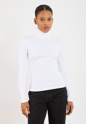 Hvit langermet turtleneck i ribbestrikket stoff, tettsittende design, sammen med svarte høytlivsjeans, glatt tekstur og klassisk silhuett.