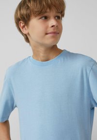 Lichtblauwe katoenen t-shirt met korte mouwen en een ronde halslijn. Gladde textuur en eenvoudig ontwerp zonder zichtbare patronen of accenten.