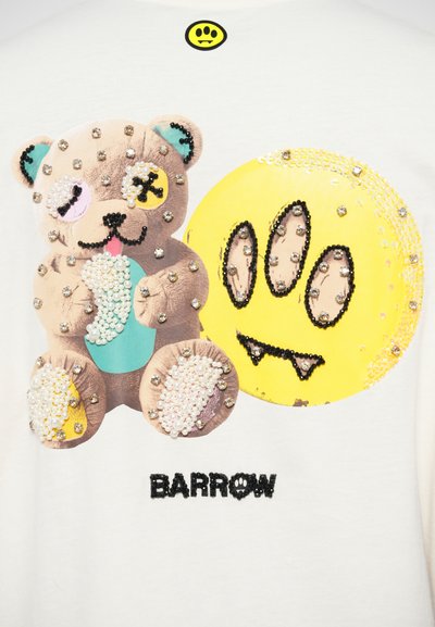 White T-shirt featuring a detailed graphic of a bear and a yellow smiley face. Accented with beads and sequins. Brand name "BARROW" displayed.