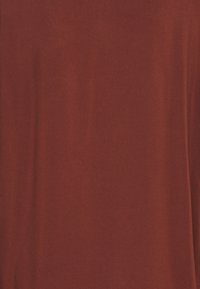 Tissu orange brûlé avec une texture lisse et une couleur uniforme. Aucun motif ni détail notable n'est présent.