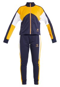 Survêtement de sport bleu marine, jaune et blanc avec veste zippée et pantalon assorti, avec le logo Hummel sur la veste et le pantalon.