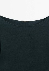 Pull en maille vert foncé avec un large col rond et une petite étiquette noire à l'intérieur du col portant l'inscription "Massimo Dutti".