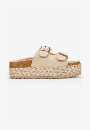 Sandalias de plataforma beige con dos hebillas ajustables, parte superior de efecto ante, suela de yute trenzado y una entresuela de corcho. Suela plana y texturizada.