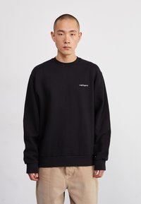 Black sweatshirt made of cotton, featuring a crew neck and long sleeves. It has a small white logo on the left chest area.