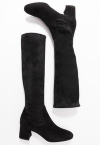 Schwarze Overknee-Stiefel aus weichem Wildleder, mit runder Zehenform, Blockabsatz und nahtlosem Design sowie einem gerippten Akzent am oberen Rand.