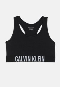 Svart Calvin Klein sportbh för ungdomar, racerback-stil, elastisk rem med vit Calvin Klein-logotyp i nederkant.