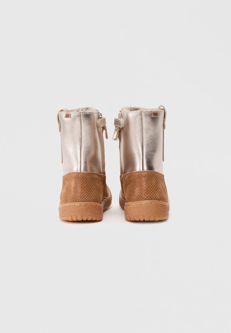 Metallic silberne Knöchelstiefel mit einem unteren Bereich aus tanfarbenem Textil, Reißverschluss und weichem Innenfutter. Flache Gummisohlen mit Traktionsmuster.