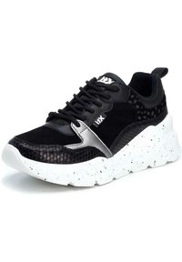 Sneaker nera con un mix di materiali testurizzati, inclusi pattern lisci e a stampa serpente. Caratterizzata da una suola bianca maculata e un accento con il logo.