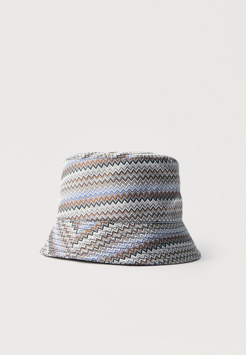 Bucket hat with zigzag pattern in white, brown, black, and blue tones against plain light background.