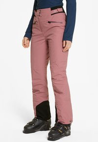 Pantaloni da sci impermeabili rosa con una vestibilità rilassata, dotati di accenti neri alle caviglie, molteplici tasche e vita regolabile con bottoni.
