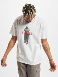 Hvid bomulds t-shirt med et grafisk motiv af en figur i mørkt tøj, med teksten "THE NOTORIOUS B.I.G." i rød. Løs pasform, rund halsudskæring.