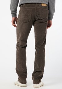 Bruna manchesterbyxor med rak passform, bakfickor, en strukturerad yta och en läderetikett nära midjan.