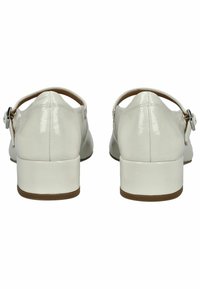 Scarpe in pelle sintetica bianca con tacco basso a blocco, design open back e cinturino alla caviglia regolabile. Superficie liscia con finitura lucida.