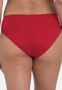 Red bikini bottom with a classic high-cut design. Smooth fabric texture, no patterns, with a clean finish along the edges.