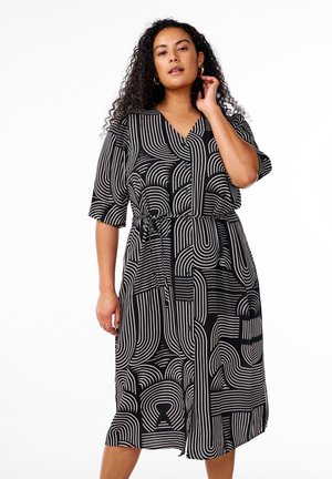 Schwarzes Kleid mit weißen abstrakten Linien, kurzen Ärmeln, V-Ausschnitt, tailliertem Schnitt, knielang, mit geschwungenen und geometrischen Mustern.