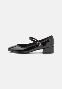 Black patent leather Mary Jane shoe with a rounded toe, small block heel, and an adjustable strap with a metal buckle. Smooth texture.