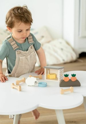 Drevný herný set obsahuje bieleho ovcu, mrkvy, modrú miskou a domček so syrom. Usporiadané na bielom stole s oblým tvarom.