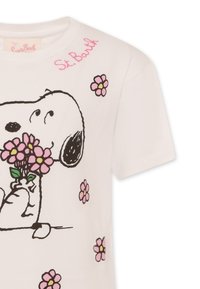 T-shirt in cotone bianco con un disegno di un cane in cartoon a contorno nero che tiene dei fiori rosa, con dettagli floreali rosa e la dicitura "St. Barth" ricamata in rosa.
