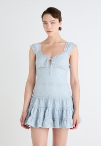 Svijetloplava čipkana haljina s volanima, dekolteom u obliku suzice i čipkastim naramenicama. Ima složene uzorke i prilagođen korzet.