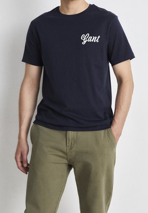 Navy blue cotton t-shirt with short sleeves and a crew neck, featuring a white "Gant" logo on the left chest area.