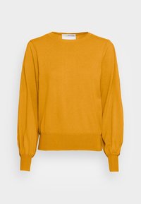 Senapsgul långärmad tröja med ribbade ärmslut och nederkant, rundad halsringning och avslappnad passform på vit bakgrund.