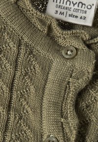 Olivgrüner Bio-Baumwollcardigan mit strukturiertem Strickmuster, fröhlichem Halsausschnitt und einem einzelnen, hellen Knopfdetail. Größenetikett sichtbar.
