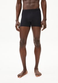 Schwarze Boxer aus weichem, dehnbarem Stoff, mit einer engen Passform und einem bequemen Bund, auf dem die Markenbezeichnung "ARMEDANGELS" geprägt ist.