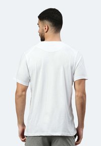 T-shirt bianco in cotone con maniche corte, collo rotondo e vestibilità rilassata. Tessuto liscio senza motivi o accenti visibili sul retro.