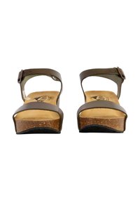 Sandales en cuir marron avec deux brides, une boucle à la cheville et une semelle en liège. La semelle est texturée, offrant une bonne adhérence.