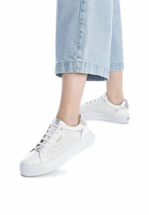 Zapatillas blancas con un patrón floral texturizado, acentos plateados y una suela blanca gruesa. Cordones en la parte delantera y marca en el lateral.